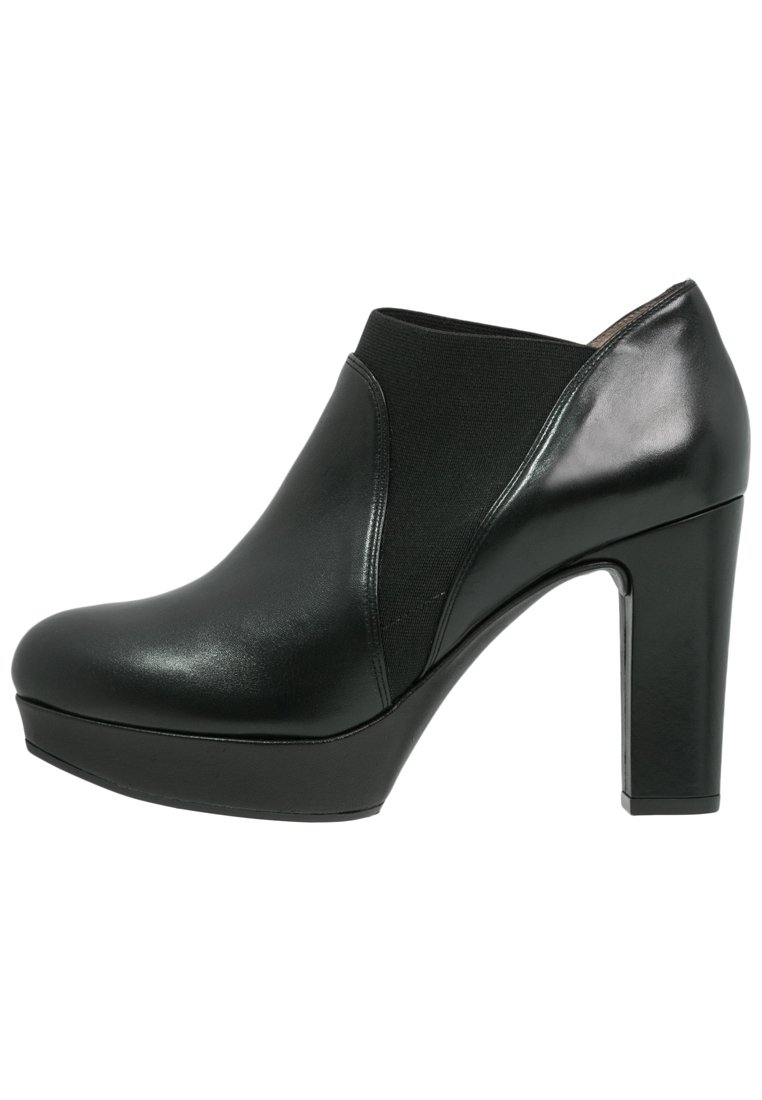 Bottines à talons hauts noires avec une finition en cuir lisse, un panneau élastique, un bout rond et une semelle épaisse. Accent poli sur le talon.