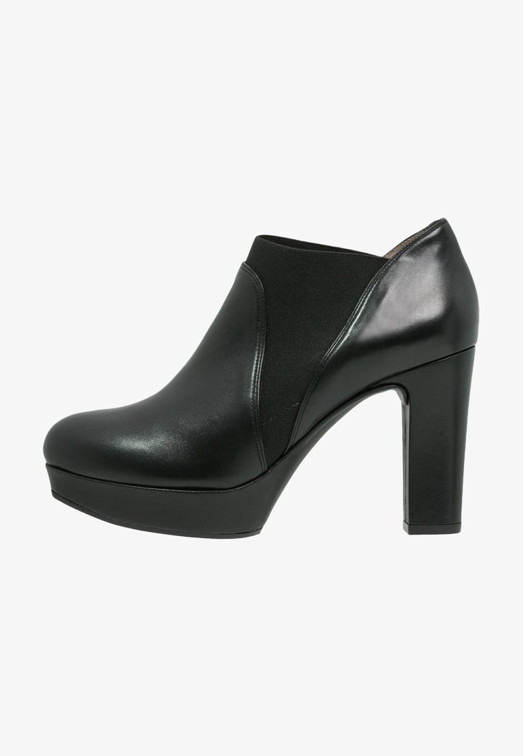 Bottines à talons hauts noires avec une finition en cuir lisse, un panneau élastique, un bout rond et une semelle épaisse. Accent poli sur le talon.