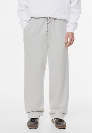 Lichtgrijze sweatpants van zacht materiaal, met een losse pasvorm, elastische tailleband met koord en zijzakken.
