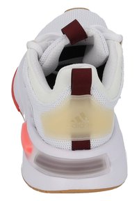 White athletic shoe with mesh upper, red accents, and a gum sole. Features padded collar and translucent heel support with logo detail.