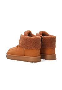 Braune Wildleder-Stiefeletten mit einem weichen, plüschigen Fellaufschlag. Leichte Gummisohle und genähte Details an der Oberseite. Hintere Reißverschlussöffnung.