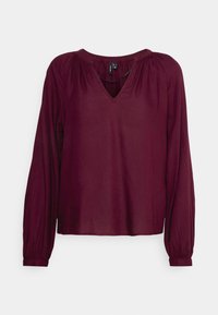 Blusa bordeaux a maniche lunghe con scollo a V, cuciture delle spalle arricciate e polsini elasticizzati. Realizzata in tessuto leggero e liscio.