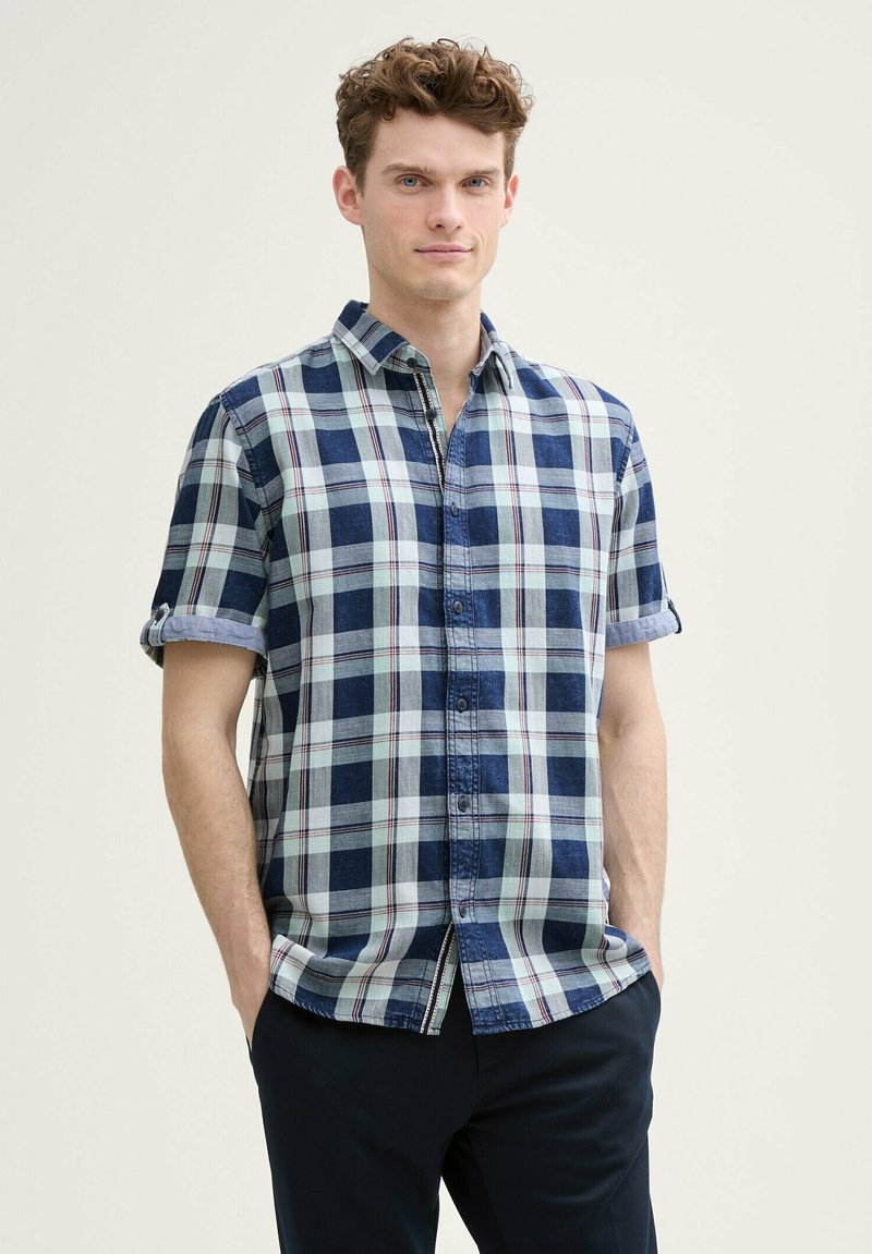 Kurzarm-Hemd aus kariertem Stoff in Blau, Weiß und Rot. Mit Button-Down-Kragen und hochgerollten Ärmeln. Baumwollmaterial mit weicher Textur.