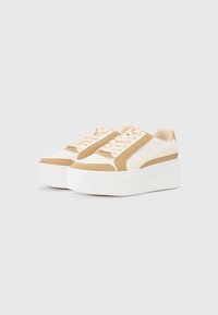 Baskets à plateforme avec une semelle blanche, des accents en daim beige, des côtés en mesh et des lacets crème ; forme arrondie avec une texture antidérapante sur la semelle.