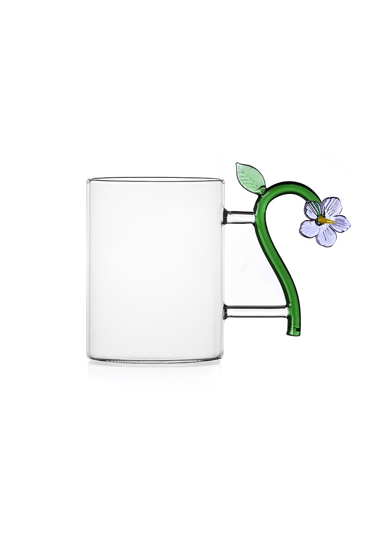 Heldere glazen mok met een groene bloemenhandgreep met paarse bloemen en bladdetails. Cilindrische vorm met een gladde textuur.