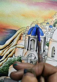 Aquarel kunstwerk dat een kustdorp toont met witte gebouwen en blauwe koepels. Penseel vastgehouden met verf op een gestructureerd oppervlak.