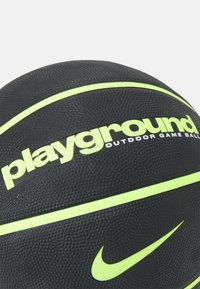 Balón de baloncesto negro con superficie texturizada, con detalles en verde neón y marca que incluye "playground" y un swoosh de Nike.
