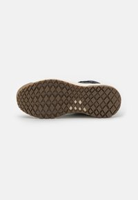 Suela de zapato de material de goma, con un patrón texturizado de pequeños diamantes y cuadrados, en marrón con acentos de color claro.