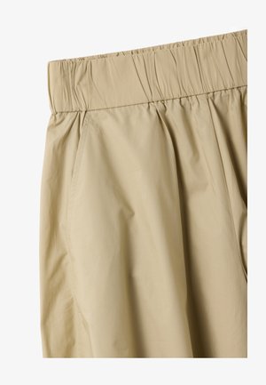 Pantalones beige con cintura elástica, bolsillos laterales y tejido liso y ligero.