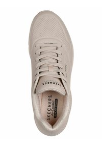 Beige Skechers Sneaker mit durchbrochenem Design, flachen Schnürsenkeln und gepolstertem Fußbett mit der Bezeichnung "Air-Cooled Memory Foam". Runde Zehenpartie und glatte Textur.