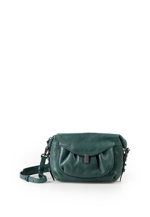 Kleine donkergroene leren crossbodytas met voorvak met klep en verstelbare riem op een witte achtergrond.