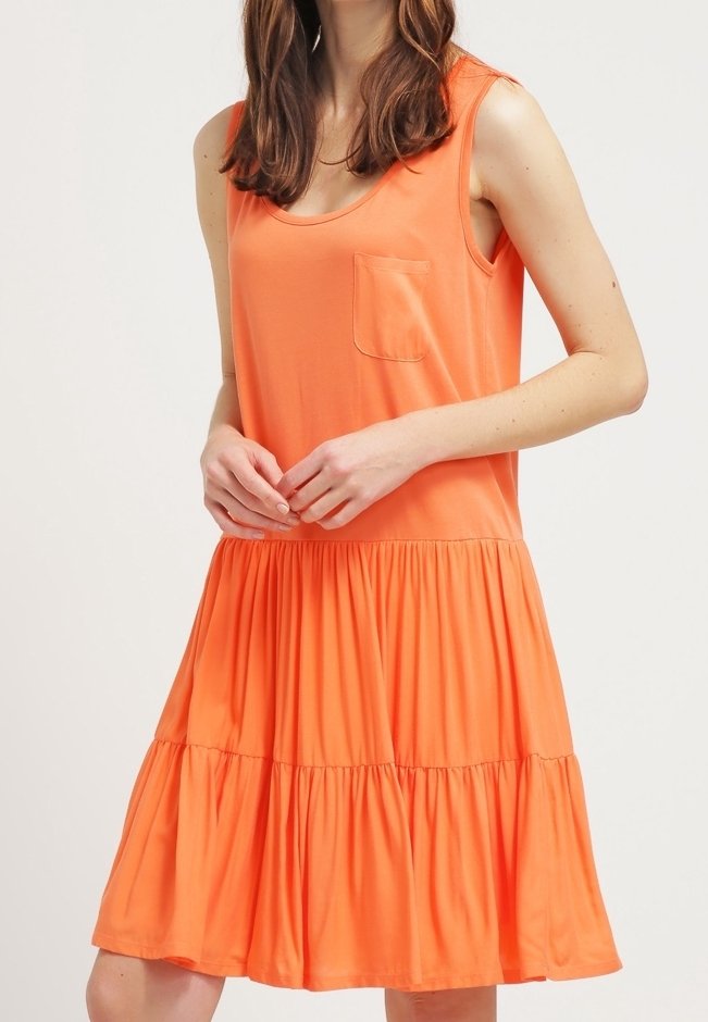 Oranžové bezramínkové šaty s přiléhavým korzetem a vrstvenou sukní, které mají malou kapsičku na prsou a jsou vyrobené z měkké, lehké látky.