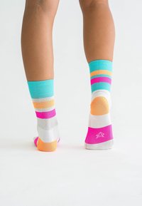 Bunte Socken mit einem gestreiften Muster in Türkis, Orange, Pink und Weiß. Gerippte Bündchen und kontrastierende Fersen- und Zehenbereiche.