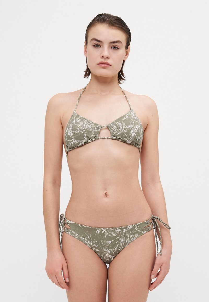 Bikini set u maslinastoj zelenoj boji; halter top s prorezom, tkanina s uzorkom; podesive vezice sa strane donjih dijelova. Glatka tekstura.