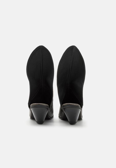 Chaussures noires à talons avec un design à embout pointu, texture en cuir lisse et doublure intérieure grise ; dotées d'un petit talon en forme de cône.