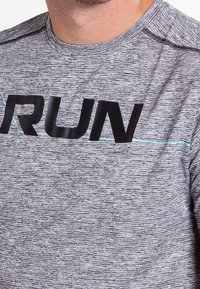 Grå atletisk tröja med en texturerad design, prydd med en svart "RUN"-tryck och en horisontell accentlinje i teal över bröstet.