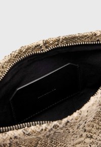 Gezipperte Handtasche mit einem strukturierten beige- und braunfarbenen Schlangenprint-Außenteil, ausgestattet mit einem schwarzen Innenraum und einer flachen Tasche innen, gefüttert mit glattem Stoff.