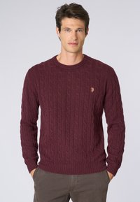 Maglione bordeaux a trecce con scollatura rotonda, polsini e orlo a costine; presenta un piccolo logo ricamato sul petto.