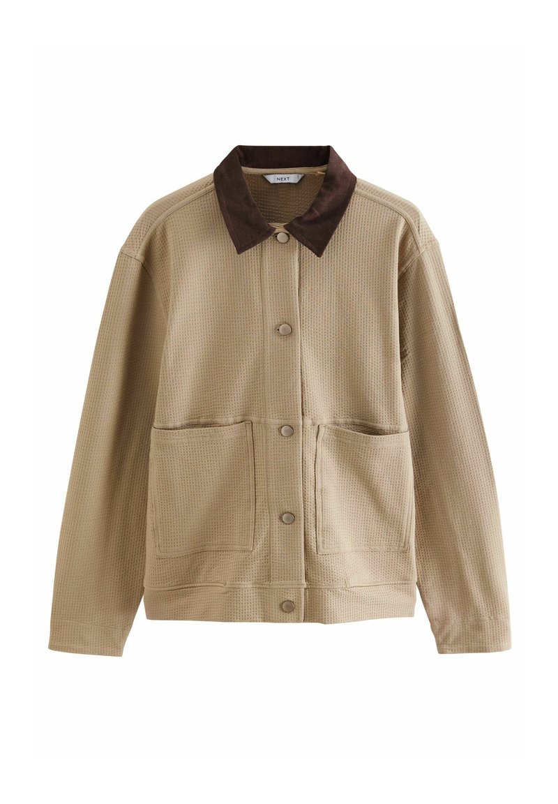 Veste texturée beige avec un col en daim marron, deux poches avant et des fermetures à boutons. Présente une coupe décontractée et des détails de coutures visibles.