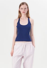 Navy blue tank topp laget av bomull, med scoop-hals og tykke stropper, kombinert med lyserosa bukser med striper og elastisk linning.