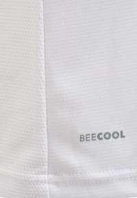 Gros plan sur un tissu blanc texturé avec un motif alvéolé et « BEECOOL » imprimé en gris dans le coin inférieur droit.