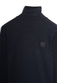 Mornarska rolka s rebrastom, koja ima visoki ovratnik i malu brendiranu oznaku na prsima. Mekana, elastična tkanina.