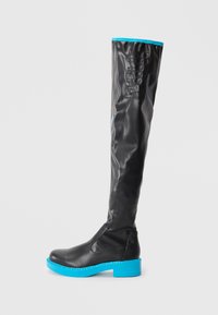 Black knee-high boot with a glossy finish, featuring a blue rubber sole and accents. Designed with a sleek shape and minimal hardware.