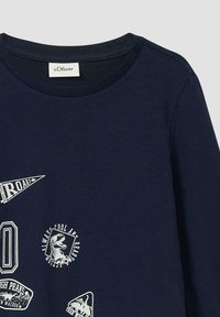 Marineblauw langemouw t-shirt met witte grafische prints, waaronder dinosaurussen en tekst, met een ronde halslijn en een zachte stofstructuur.