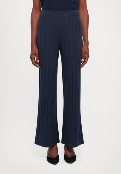 Navy ribbelgebreide broeken met een uitlopende onderkant en een elastische tailleband, voorzien van verticale strepen voor extra textuur.
