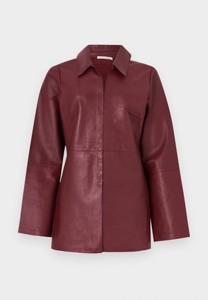 Jachetă din piele burgundy cu mâneci lungi, guler și fermoar frontal, croială ajustată și textură netedă.