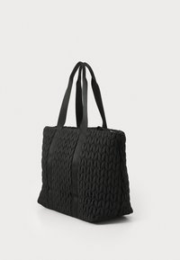 Borsa a rete nera con superficie testurizzata, dotata di due manici in tessuto e forma rettangolare. Chiusura con zip sulla parte superiore.