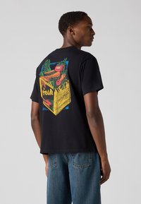 Black cotton t-shirt featuring a colorful graphic of a crate with vegetables and the word "fresh" on the back. Short sleeves, relaxed fit.