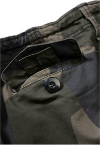 Kamuflagebyxor med en svart knapp och en bakficka. Tyget har en strukturerad, hållbar look med mönster i mörkgrön och grå.