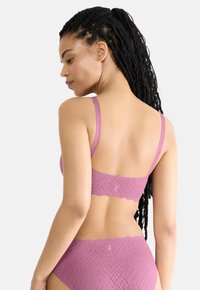 Svetlofialová čipkovaná podprsenka a zodpovedajúci nohavičky s textúrovaným diamantovým vzorom a vlnitými okrajmi, s tenkými ramienkami a detailom loga.