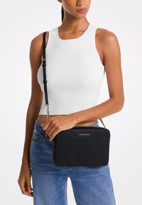 Sort crossbody taske med en struktureret form, tekstureret materiale, guldfarvet hardware og logo detaljer. Har en aftagelig kædestrop.