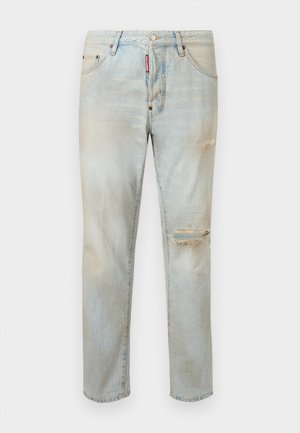 Jean en denim clair avec déchirures usées sur la cuisse droite et le genou, conception à cinq poches, et étiquette de marque rouge sur la zone de la fermeture éclair avant.