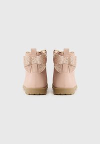 Bottines roses en cuir avec des nœuds en paillettes dorées et des bords festonnés, dotées d'une semelle en caoutchouc pour une meilleure adhérence et durabilité.