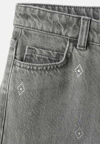 Pantaloni in denim grigio con una piccola tasca frontale e decorazioni a forma di diamante con accenti trasparenti. Tessuto testurizzato con cuciture visibili.