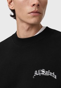 Felpa nera con scollo rotondo, caratterizzata da logo "All Saints London" ricamato in bianco sul petto. Tessuto dalla trama liscia.