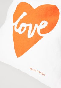 Bomulls tote bag med et oransje hjertegrafikk og ordet "love" i hvitt. Merkenavnet "Marc O’Polo" trykket i oransje.