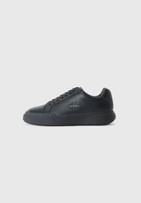 Zwarte leren sneakers hebben een ronde neus, platte zool en vetersluiting. Opvallende details zijn onder andere een subtiel logo aan de zijkant.