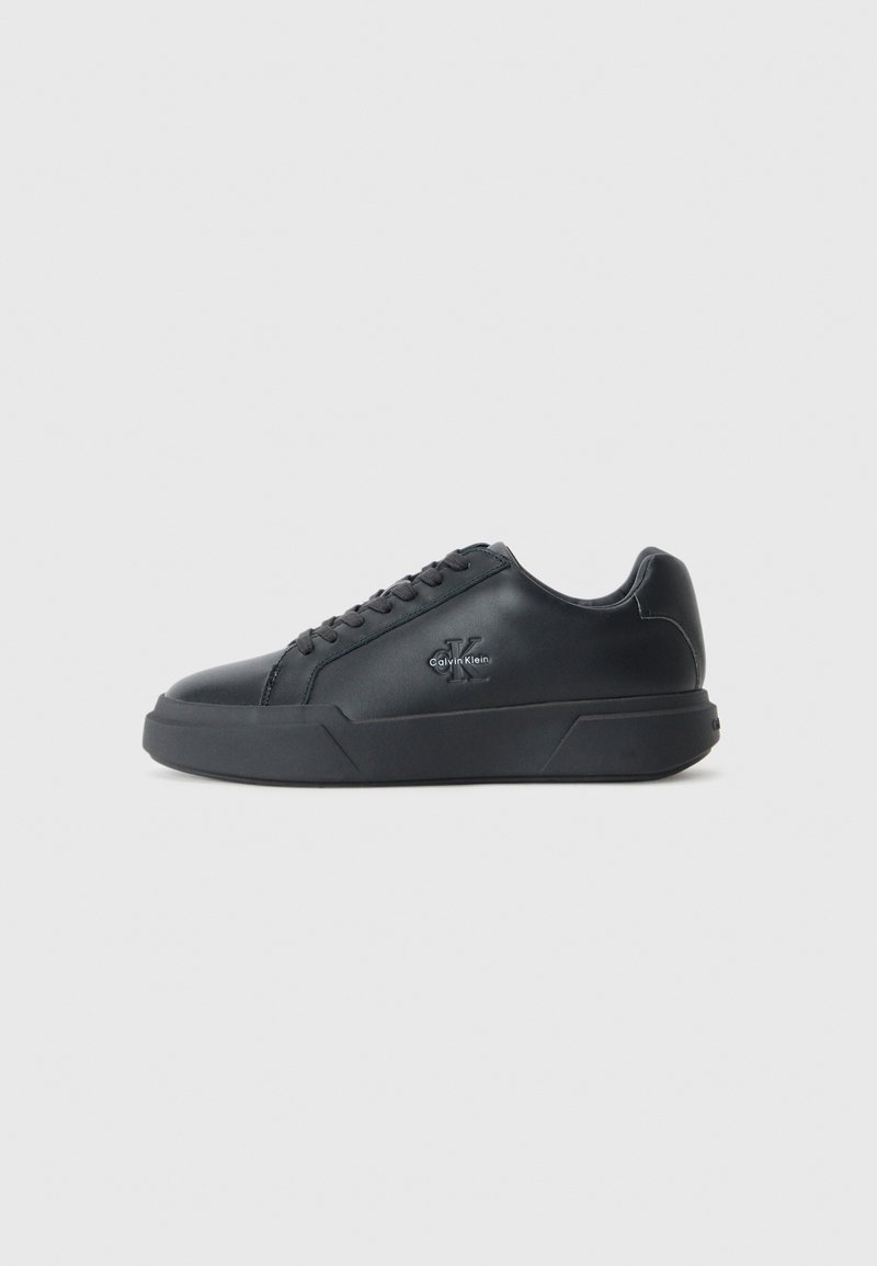 Zwarte leren sneakers hebben een ronde neus, platte zool en vetersluiting. Opvallende details zijn onder andere een subtiel logo aan de zijkant.