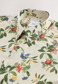 Camicia a maniche corte in tessuto crema con motivi vivaci di fiori e farfalle. Bottoni e design del colletto ne valorizzano l'aspetto complessivo.