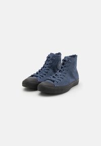 Blå semskede høyhælte sneakers med svart gummitåhette og såle, med snøring og strukturert overflate. Stjerne-logo på siden.