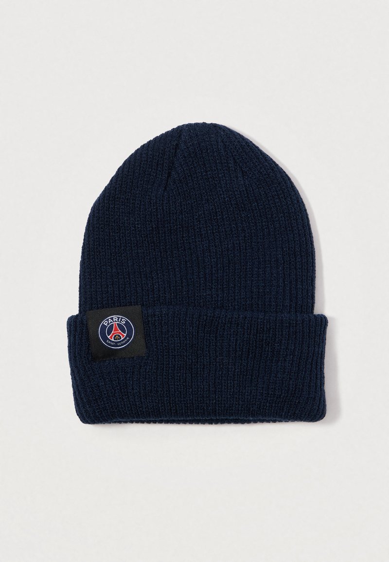 Gorro de malha azul-marinho com uma textura canelada, apresentando um patch preto com o logótipo do Paris Saint-Germain. Design de rebordo dobrado.