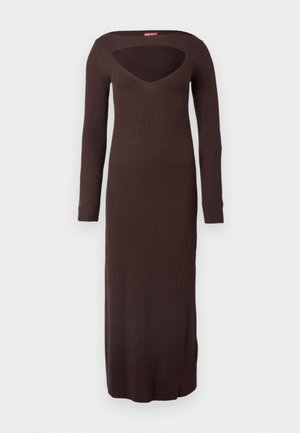 Dlouhé hnědé žebrované pletené šaty s hlubokým výstřihem do V a otevřenými zády. Mají dlouhé rukávy a podlahovou délku, zdůrazňující přiléhavý střih.