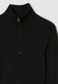 Czarny prążkowany sweter z długim rękawem, krótkim stójką i centralnym zamkiem błyskawicznym w pół długości.