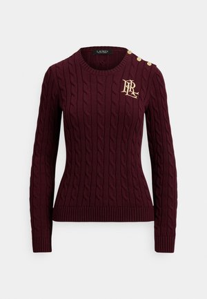 Bordinės spalvos megztinis su pynimo raštu, su ribbota apačia ir rankogaliais. Ant peties yra trys auksiniai mygtukai, o krūtinėje – auksinis logotipas.