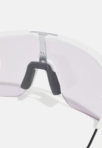 Gafas de sol deportivas blancas con un diseño ligero, lentes rosas, almohadillas de nariz de goma y acentos metálicos, que presentan una forma moderna y aerodinámica.