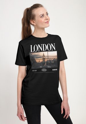 Zwart T-shirt met een fotografische print van de Big Ben in Londen, met de tekst "LONDON" en "NEXT STOP" in het wit. Casual pasvorm met korte mouwen.